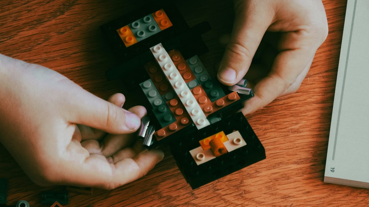 Hands rebuilding a used LEGO set to verify every piece