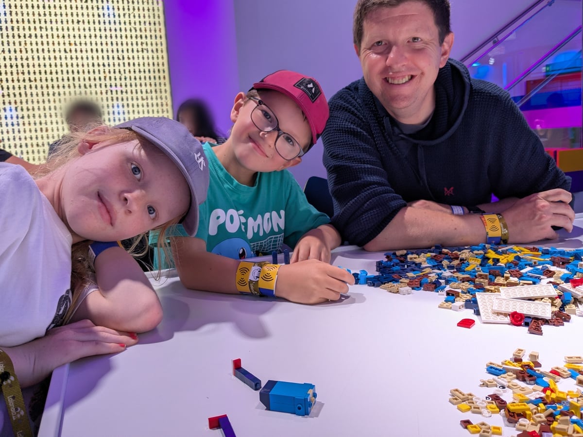 Chris, Max and Emmie Hadley building LEGO together at a table covered in bricks